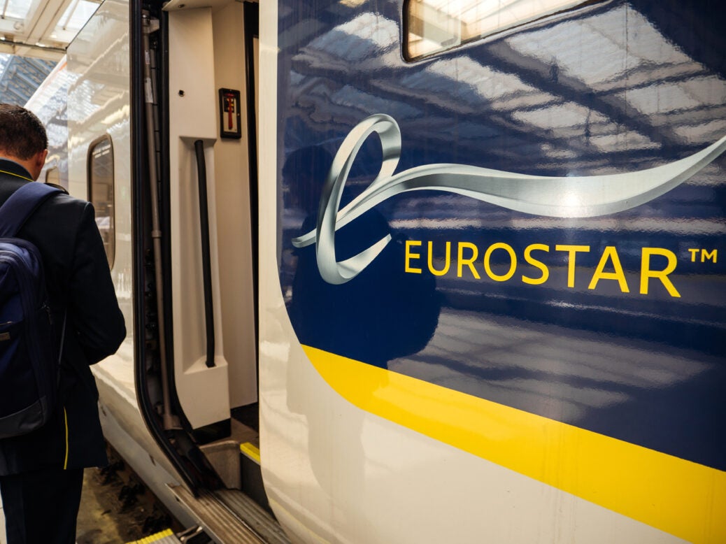 Rear view of passenger male with backpack entering the large door of the Eurostar train in St Pancras train station. Eurostar will offer free travel to Ukraine nationals.