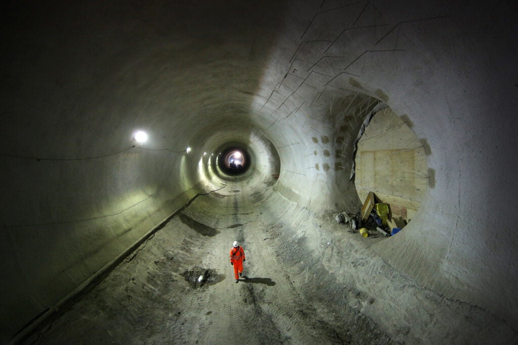 Darbuotojas eina per iš dalies užbaigtą Crossrail Bond Street stoties tunelį.