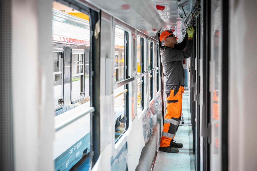 A photo of a worker renovating a french night train carriage