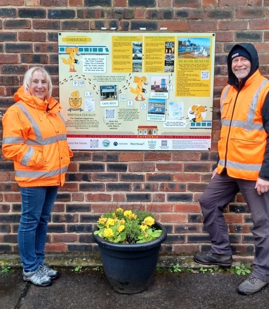 Northern regional station manager Jane Murray alongside Warren Birch, Community Rail Partnership officer for Cumbria Coast. In front of the information panel at Corkickle