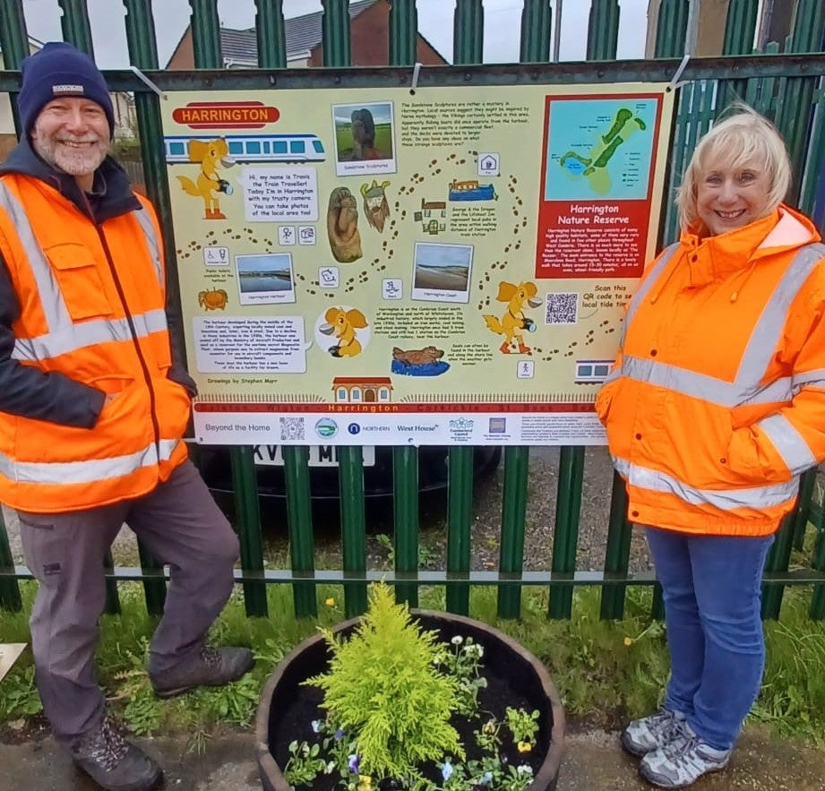 Northern regional station manager Jane Murray alongside Warren Birch, Community Rail Partnership officer for Cumbria Coast. In front of the information panel at Harrington