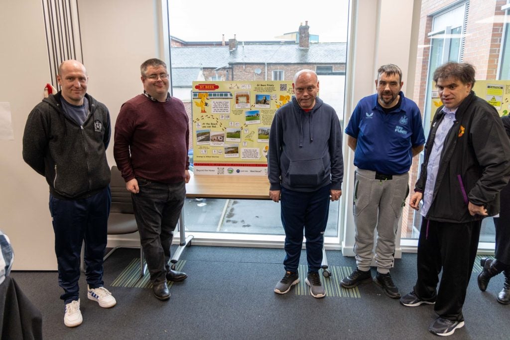 A group of people in front of the Makaton information panels